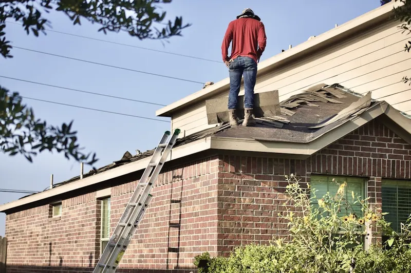 Professional roofer working on a residential roof in Mastic Beach